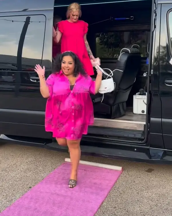 Woman stepping out of a TIED Sprinter onto a pink carpet